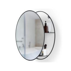 a bathroom mirror that is hanging on the wall next to a shelf with soap and lotion