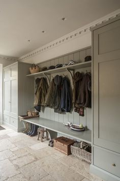 a coat rack filled with coats and shoes next to a wall full of closets