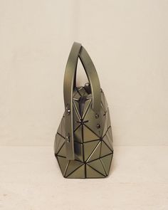 Boston bag by Bao Bao Issey Miyake in khaki green. Classic hand or shoulder bag with twin adjustable straps. Handy size with sturdy base and studded feet. Compact rectanguar shape offers a deceivingly spacious capacity, while the signature triangular motif has a reflective leather-like finish. H 16.5cm x W 33cm.Polyvinyl Chloride, Polyster, Nylon.Made in Japan. Bao Bao Issey Miyake, Bao Bao, Polyvinyl Chloride, Boston Bag, Issey Miyake, Khaki Green, Green Bag, Baguette, Made In Japan