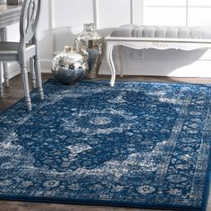 a blue area rug with an ornate design in the middle and two chairs on either side