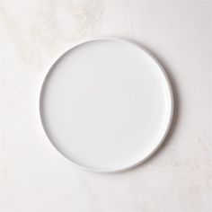 an empty white plate on a marble surface