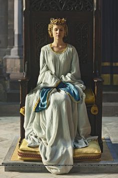 a statue sitting on top of a wooden chair