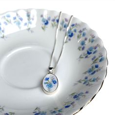 "Simple and delicate, this forget me not broken china necklace, featuring a dainty broken china pendant handcrafted from a vintage forget me not china plate, makes a thoughtful jewelry gift for her for any occasion. As the name indicates, the forget me not flower symbolizes love and remembrance, promising that you will never forget a person in your thoughts. It also symbolizes a connection that endures all challenges and measure of time. It is no coincidence that this forget me not china pendant Forget Me Not Flower Necklace, Forget Me Not Pendant, Forget Me Not Flower Jewelry, Forget Me Not Necklace, Forget Me Not Jewelry, Porcelain Necklace, Forget Me Not Flower, Thoughtful Gifts For Her, Broken China Jewelry