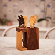 two wooden utensils in a holder on a table