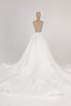 the back of a white wedding dress on a mannequin headdress,