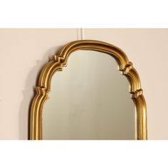 an ornate gold framed mirror against a wall