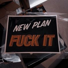 a sign that says new plan f k it on the side of a pile of boxes