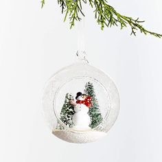 a snowman ornament hanging from a christmas tree