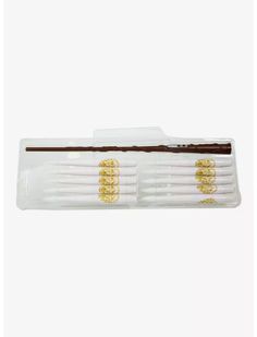 two toothbrushes with gold designs on them sitting in a plastic case, one is white and the other is brown