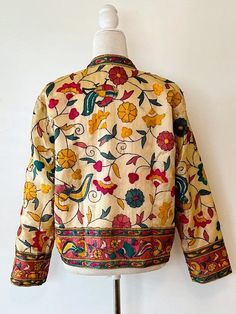 This traditional cotton jacket is refined, classic yet colorful. Incorporates a multitude of colors that will compliment your existing wardrobe. Fully embroidered on all sides, mixed colors which may be worn in all seasons. Embroidery is subtle, without embellishments, 3/4 sleeves, fully lined, open duster style. Made of cotton with unique stylish embroidery and printing. A unique combination of colorful embroidery in a floral and bird pattern. Impressive enginnered border running the front panels, tab neck, and sleeves.Designed to be worn open, easy fit. On trend, versatile and comfortable. It Is perfect for any event and great for travel. The traditional embroidery patterns are perfect for the boho look of the season. Consider purchasing for a special gift; wedding, anniversary, holiday, Fall Multicolor Embroidered Nehru Jacket, Fall Long Sleeve Outerwear With Embroidered Border, Traditional Nehru Jacket With Embroidered Border For Spring, Nehru Jacket With Multicolor Resham Embroidery For Fall, Traditional Nehru Jacket With Floral Embroidery For Fall, Embroidered Cotton Outerwear With Stand Collar, Multicolor Resham Embroidered Nehru Jacket For Fall, Fall Nehru Jacket With Multicolor Resham Embroidery, Embroidered Nehru Jacket With Stand Collar For Fall