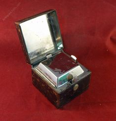 an old fashioned record player sitting on top of a red cloth covered floor with its lid open