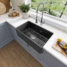 a kitchen sink sitting under a window next to a cutting board and utensils