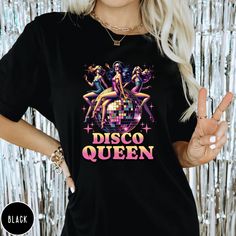 Step into the spotlight and let your inner Disco Queen shine with our exclusive Retro Vibes Disco Queen T-shirt! Designed for those who love to dance through the decades, this tee is a perfect blend of style and comfort. Embrace the groove and express your love for disco music with every step. .: 6.1 oz., 100% ring spun USA cotton .: Preshrunk, soft-washed, garment-dyed fabric .: Made with sustainably and fairly grown USA cotton & sewn with USA cotton thread .: Relaxed fit & Sewn-in Twill Label .: Print Method: DIGISOFT® SIZE GUIDE Tees are Unisex so have a slightly oversized look on women, we recommend you to go down a size for a slimmer fit. Fit is truer to size for men. You can find the size guide in the listing photos with measurements in inches for garment width and body length. Pleas Party T-shirt With Funny Print, Party T-shirt With Text Print, Party T-shirt With Text Print And Short Sleeves, Fitted Graphic Print T-shirt For Party, Vintage Party Tops With Letter Print, Vintage Letter Print Tops For Party, Trendy Graphic Print T-shirt For Parties, Crew Neck T-shirt With Graphic Print For Party Season, Graphic Print Crew Neck T-shirt For Party Season