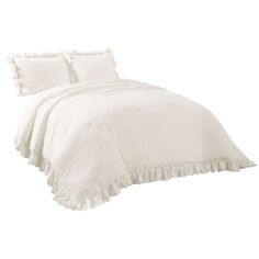 a white bed with ruffled edges and pillows