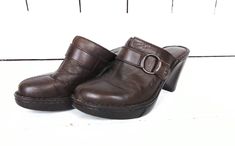 "Dark brown leather Born clogs/leather wedge sandals/Born slip on mules/shoes/38/7 Measurements... -marked size: 38/7 -insole: 9.5\" -width at ball: 3.25\" -heel: 3.5\" Features... -leather upper in a dark brown hue -decorative leather belt buckle detail -classic clog slip on style -padded leather insole -chunky rubber wedge heel -brand: Born Condition... -great vintage condition -some wear on soles but still in great shape -minor scuffing on heels -gently worn 1I3215" Leather Platform Slip-on Mules, Leather Pointed Toe Platform Mules, Casual Platform Mules With Pointed Toe, Casual Wedge Heel Mules With Heel Loop, Casual Mules With Heel Loop And Wedge Heel, Casual Mules With Wedge Heel And Heel Loop, Casual Leather Clogs With Pointed Toe, Casual Leather Pointed Toe Clogs, Casual Brown Clogs With Pointed Toe