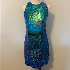 New With Tags! Gorgeous Tfnc London Dress Mermaid Size 4. Blue/Green Shiny Sequins On Sheer Material With Solid Blue Liner Layer Underneath. High Neck, Back Cutout With Button Loop Closure At The Back Top Neck. A Few Areas Have Missing Sequins, Can Be Repaired With Replacement Sequins. Not Noticeable If Not Repaired With Sequins. But Will Need Threads Tied Off To Prevent More Coming Off. Selling As Is. Hidden Side Zipper With Hook And Eye Closure. Scalloped Hem With Clam Like Sequins. Blue Mermaid Dresses For Party Season, Spring Blue Mermaid Dress, Blue Embellished Sequin Summer Dress, Blue Embellished Sequin Dress For Summer, Blue Fitted Sequin Dress For Summer, Fitted Blue Sequin Summer Dress, Fitted Blue Sequin Dress For Summer, Fitted Embellished Mermaid Dresses, Glamorous Mermaid Summer Dress