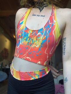 "Ready to Ship! Allow 2 weeks max for shipping! V-neck halter style tank top with straps that tie behind the neck in the pattern Tropical Trip from June's artist series prints by @taayloroakesss. The usual $5 for the artist will be donated to Zebra Youth in honor of Pride Month.  More info here: https://zebrayouth.org SIZING:  S 25-27\" waist, 36-39\" hip, 32-34\" bust Pattern fabric contents: 93% Cotton, 7% spandex" Summer Yoga Tank Top With Built-in Bra, Summer Multicolor Tops With Built-in Bra, Printed Stretch Tank Top For Summer, Casual Multicolor Tops With Built-in Bra, Fitted Racerback Crop Top With Graphic Print, Fitted Graphic Print Crop Top With Racerback, Red Halter Top With Built-in Bra For Summer, Fitted Printed Tank Top, Trendy Printed Tank Top