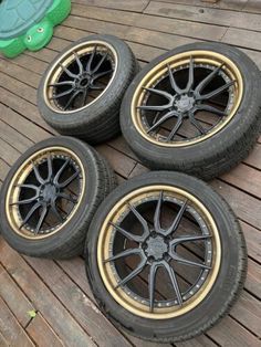 four rims and tires are laying on the ground next to a turtle toy,