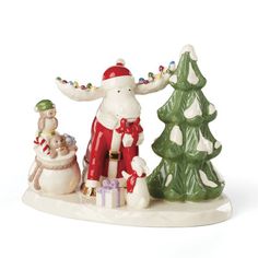 a santa clause figurine standing next to a christmas tree