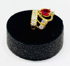 This deluxe ring features a crown adorned with a heart shaped red cubic zirconia as the center stone elegantly matched with white cubic zirconia stones. Precious Metal: 14 Karat Yellow Gold Gemstone: Cubic Zirconia Red: Heart shaped White: Round shaped Contact us for availability with Diamonds. Height: 15.50 mm Width: 19.91 mm To check availability in other sizes and designs please inquire via e-mail or Instagram DM if necessary. *All weights are approximate. Please contact us if you have furthe Red Quince, Heart Crown, Quince Ideas, Popular Jewelry, Cz Ring, Precious Metal, Heart Jewelry, Diamond Heart, Quince