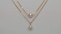 All items ordered 5/14/21 - 5/30/21 will be shipped out on 5/31/21 Our gift to you 10% off your first purchase. Details here - http:/eepurl.com/dpVPBz Tiny pearl necklace. This single pearl hangs from our signature delicate 14 k gold fill or sterling silver chain. Choose pearl drop or link/suspended style for a classic minimal look or use as a great layering piece. Please choose pearl 'drop' or 'link/suspended' style, see picture 3. The pearl is approximately 5 mm wide and is called a potato pea Double Strand Pearl Chain Necklace As Gift, Pearl Charm Layered Necklace Gift, Pearl Layered Necklace With Pearl Charm For Gifts, Gift Pearl Charm Layered Necklace, Pearl Drop Layered Necklace As Gift, Pearl Drop Layered Necklace For Gift, Elegant Pearl Layered Necklace As Gift, Elegant Pearl Layered Necklace Gift, Elegant Layered Pearl Necklace As Gift