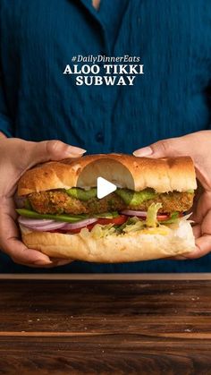 a person holding a sandwich in their hands with the caption aloo tiki subway