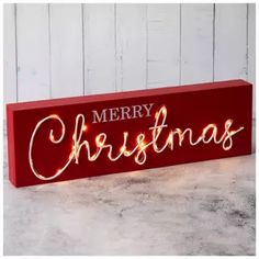 a wooden sign with merry christmas lights on it's sides and the words,