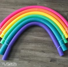 a rainbow colored pipe laying on top of a wooden floor