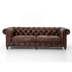 a brown leather couch sitting on top of a white floor