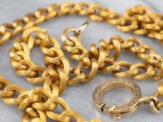 Another stunning Victorian-era piece! This antique chain necklace is crafted of 18 karat yellow gold in the distinctive style of the early 1900's Victorian era. Each of the links is grooved, with rope twist details, finished with an oversized engraved clasp. The workmanship is exquisite, and the condition is excellent, especially considering the great age of the necklace. Metal: 18K Yellow Gold Width of Chain: 7.7 mm Length of Chain: 21 Inches To view a video of this piece check out the link bel Luxury Antique Link Chain Necklace, Antique Yellow Gold Figaro Chain Necklace, Antique Oval Link Gold Chain Jewelry, Victorian Gold Necklace With Figaro Chain, Victorian Yellow Gold Jewelry With Curb Chain, Elegant Oval Link Rope Chain Necklace, Formal Engraved Link Necklaces, Formal Engraved Link Necklace, Elegant Formal Gold Chain Rope Necklace