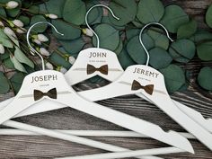 three personalized wooden clothes hangers with bow ties