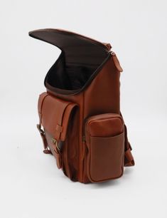 This is a classic yet elevated take on our large Generosity backpack. With its two padded backstraps, comfort will be ensured on every journey. Protect your essentials in the padded laptop pocket, and stay organized with an interior zip pocket and slip pocket. Two side zip pockets and a spacious main compartment make it extremely functional. ETHICALLY HANDCRAFTED BY STIVALI MEASUREMENTS: Length: 14" Width: 7.5" Height: 15" FEATURES/MATERIALS: Smooth leather Back luggage strap 2 padded backpack s Brown Leather Bags, Camera Backpack, Luggage Strap, Brown Leather Bag, Leather Products, Card Bag, Large Backpack, Backpack Straps, Laptop Pocket