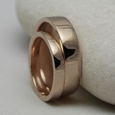 two wedding rings sitting on top of a rock