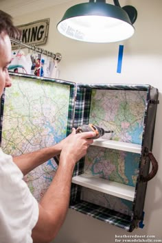 a man is looking at a map on a shelf