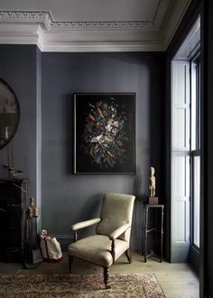 a living room filled with furniture and a painting on the wall