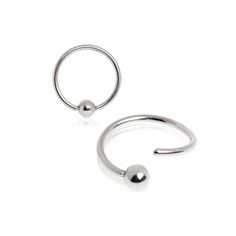 an open nose ring with a ball on the end, and a circular nose piercing