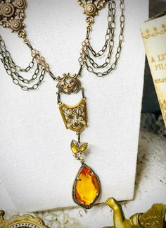 Victorian Revival Amber Teardrop Laviler Necklace~ Lightweight Teardrop is  amber colored and is prong set in the setting - setting has tiny sparkling stones at base , brass gorgeous chain adorned with various filigree sections and champagne stones !  18" necklace with an additional 2" for adjusting length ~also ends in a champagne bead ! pendant adds another 4 1/2" for a very stunning piece !  romantic and sweet piece of jewelry ! Add a touch of  vintage ! New Old Stock 1980s never worn  We shi Victorian Revival, Jewelry Design Inspiration, Bead Pendant, Victorian Jewelry, Display Ideas, Prong Setting, Amber, Jewelry Design, Beaded Necklace