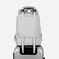 two pieces of luggage are stacked on top of each other, one is silver and the other is black