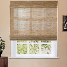 a window with a bamboo blind in front of it and a potted plant next to the window