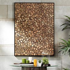 a glass table with candles on it in front of a wall covered in wood slices