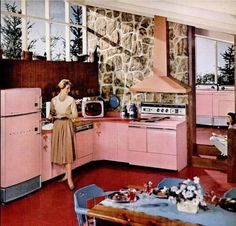 a woman standing in a kitchen next to a pink stove top oven and refrigerator freezer