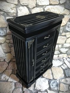 a black cabinet sitting on top of a stone floor