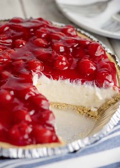 a cheesecake with cherries on top is shown in a pie tin, ready to be eaten