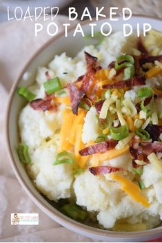 a bowl filled with mashed potatoes topped with bacon and green onions