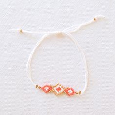 UPAVIM Crafts is excited to announce its brand new seed bead jewelry line with each piece in the collection named after one of the talented artisans who made them! Our Naomi Seed Bead Bracelet features stunning coral, white, and gold beads threaded in an incredibly delicate and intricate pattern. Lightweight and comfortable to wear - truly remarkable! As always, Handmade and Fair Trade! 100% Cotton Thread Czech Glass Seed Beads Adjustable: 4'' - 14'' Circumference Did you know that our unique se White Beaded Bracelets With Faceted Beads For Festival, White Faceted Beads Bracelets For Festival, White Delicate Adjustable Friendship Bracelets, Delicate Adjustable White Friendship Bracelets, Delicate White Adjustable Friendship Bracelets, White Faceted Beads Bracelet For Festival, White Faceted Beaded Bracelets For Festival, Delicate Adjustable Gold Beads Bracelet, Dainty White Bracelets With Colorful Beads