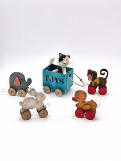 small toy animals sitting in a blue wagon with the word toys written on it's side