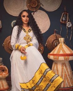 The beauty of Ethiopian traditional dress is truly a sight to behold, and the stunning yellow color of this particular garment is simply breathtaking. The dress features a flowing silhouette that drapes elegantly over the body, with intricate embroidery and beading adding texture and dimension to the fabric. The yellow color of the dress is bright and vibrant, evoking images of sunshine and warmth. As the wearer moves, the dress catches the light and shimmers, creating a truly mesmerizing effect Yellow Kaftan For Wedding And Festivals, Traditional Yellow Wedding Kaftan, Yellow Dress With Gold Embroidery For Festivals, Yellow Dresses With Gold Embroidery For Festivals, Traditional Yellow Floor-length Dress, Traditional Yellow Dress For Ceremonies, Traditional Yellow Maxi Dress For Festivals, Floor-length Yellow Dress For Festivals, Traditional Yellow Dress For Festivals