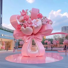 a large pink flower arrangement in the middle of a plaza