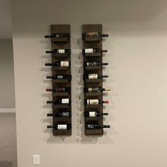 two wooden wine racks with bottles on them in a room next to a carpeted floor