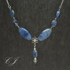 "Dumortierite is a rare blue gemstone that usually forms as inclusions in quartz. This adjustable necklace is handmade using Flower and Sunset Dumortierite beads. This classic necklace is completely handmade by Cohee Jewelry in USA.  The elegant style would be a great jewelry accessory or evening or formal wear. Matching earrings are available for both pierced and non-pierced ears.  Clasp: Handmade Sterling Silver Hook Extender: Handmade 2\" Sterling Silver Swarovski Crystal Pearl accent beads. Elegant Blue Beads Gems And Cabochons For Gifts, Labradorite Beaded Jewelry As A Gift, Elegant Blue Beads, Gems, And Cabochons As Gift, Blue Kyanite Gemstone Beaded Necklace, Blue Labradorite Gemstone Bead Necklaces, Blue Labradorite Gemstone Beads Necklace, Blue Kyanite Gemstone Bead Necklaces, Gift Labradorite Jewelry With Polished Beads, Handmade Sodalite Round Bead Necklaces